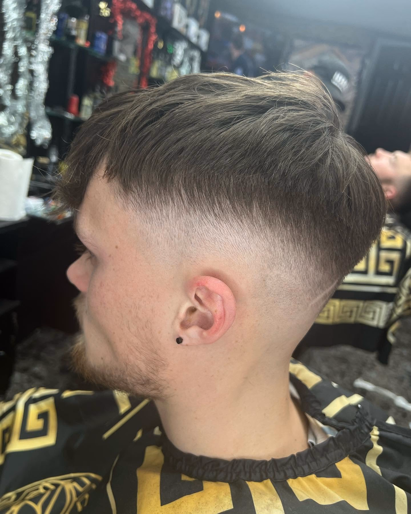 Mid drop fade with a longer textured crop swept forward on top, rear three-quarter view